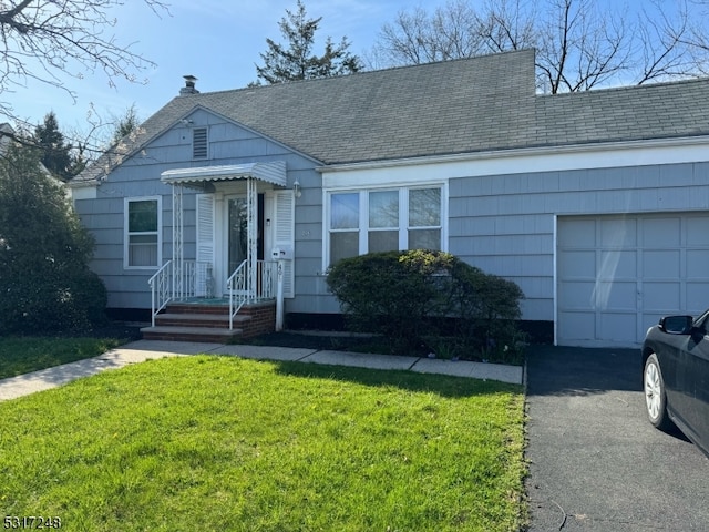 view of front of home with a garage and a front lawn