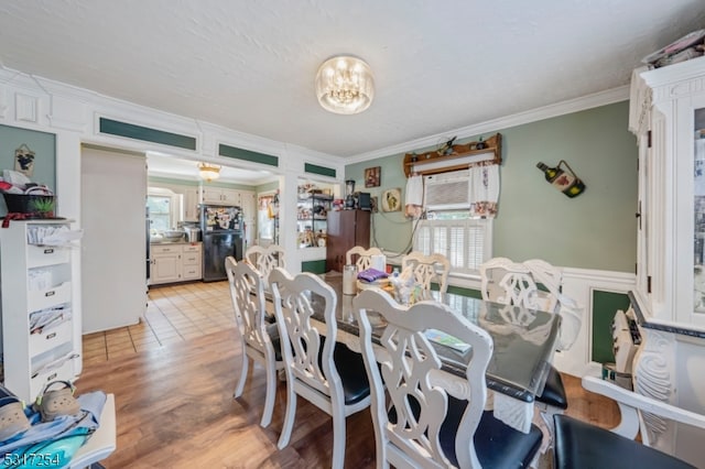 dining space with ornamental molding, an AC wall unit, light hardwood / wood-style flooring, and plenty of natural light