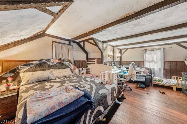 bedroom featuring wood-type flooring, wood walls, and beamed ceiling