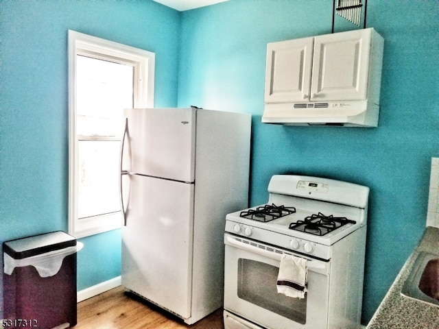 kitchen with white cabinets, light wood-type flooring, and white appliances