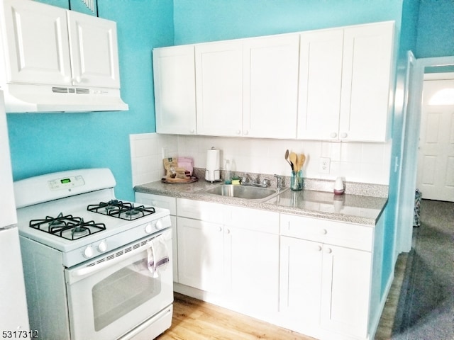 kitchen featuring white range with gas stovetop, sink, and white cabinets