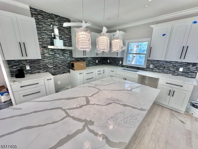 kitchen with light stone counters, backsplash, and white cabinetry