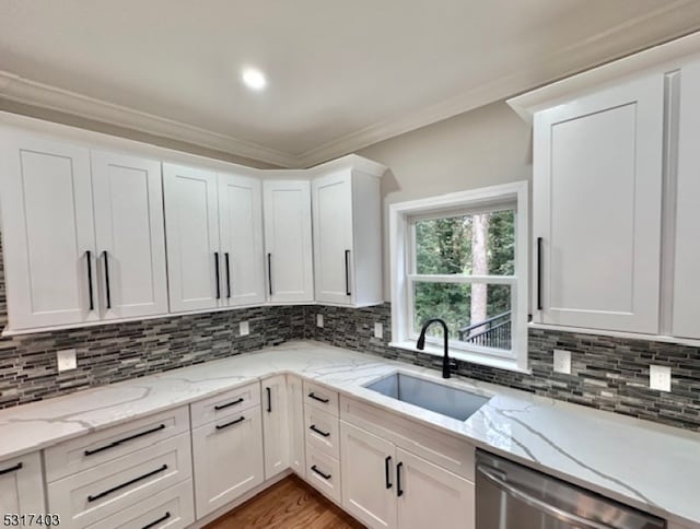 kitchen featuring dishwasher, white cabinetry, sink, and light stone counters