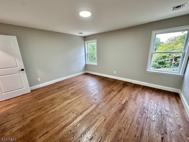 empty room featuring hardwood / wood-style flooring and plenty of natural light