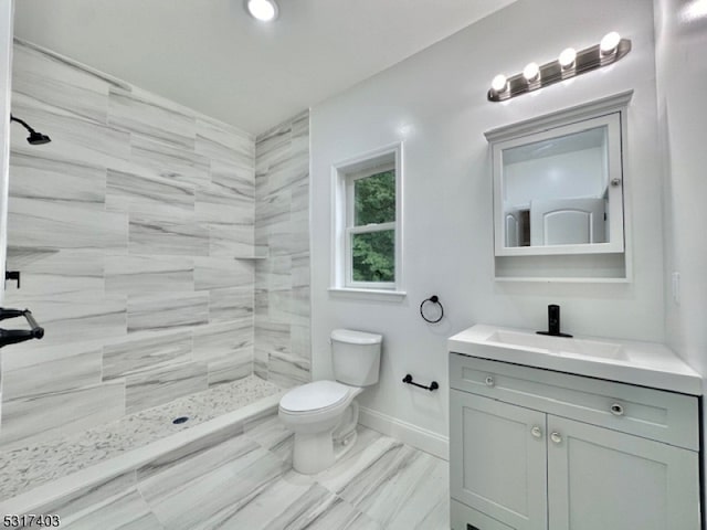 bathroom with tiled shower, vanity, toilet, and hardwood / wood-style flooring