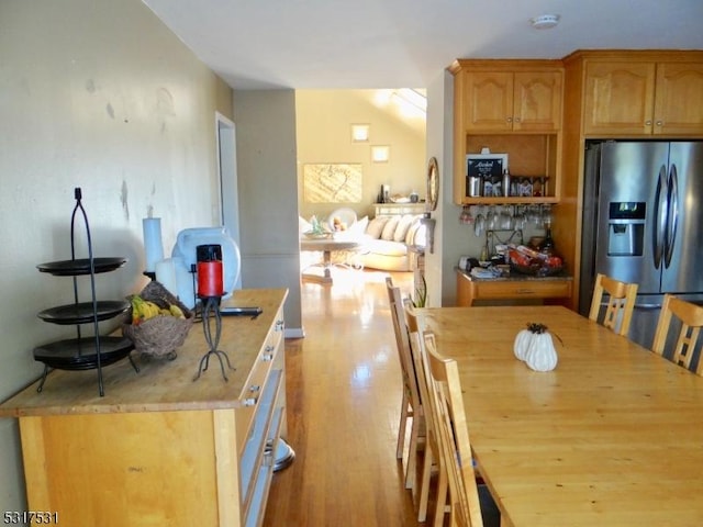 kitchen with light wood-style flooring and stainless steel fridge with ice dispenser