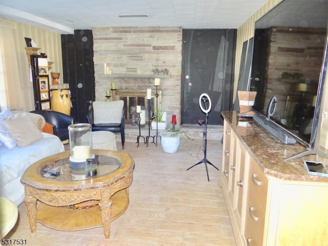 living room with light wood-type flooring and a large fireplace