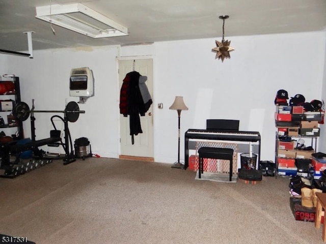 workout room with heating unit and carpet