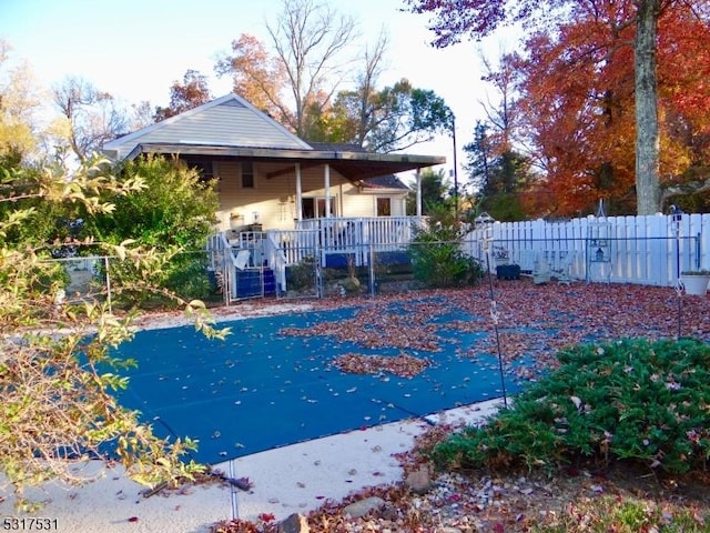 view of swimming pool with a porch and fence