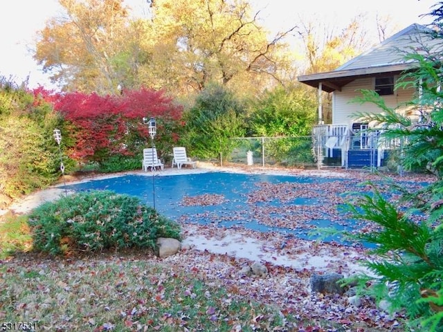 view of swimming pool featuring a covered pool and fence