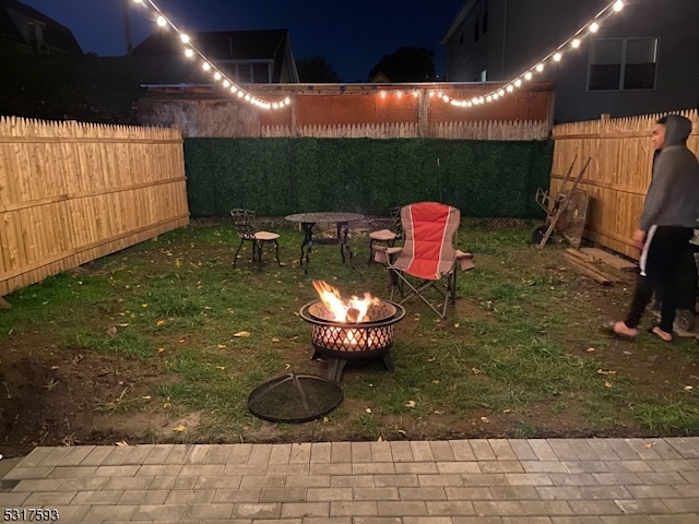 yard at twilight featuring an outdoor fire pit