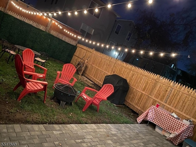 patio at twilight with an outdoor fire pit and grilling area