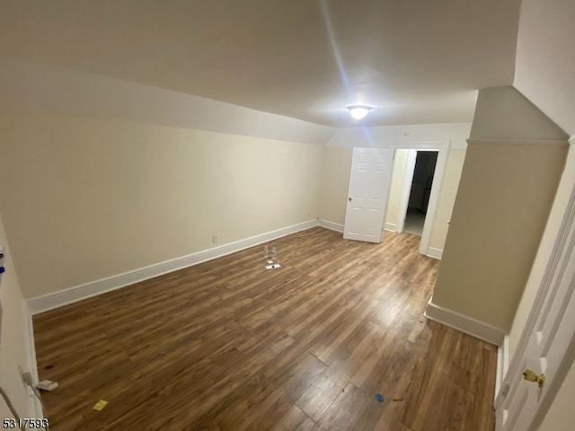 additional living space with vaulted ceiling and dark hardwood / wood-style floors