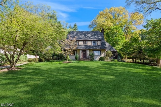 tudor-style house with a front lawn