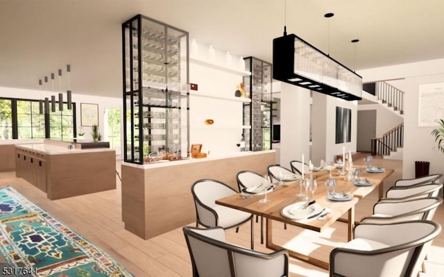 dining room featuring light wood-type flooring and a high ceiling