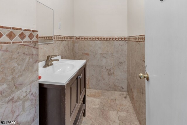 bathroom with tile walls and vanity