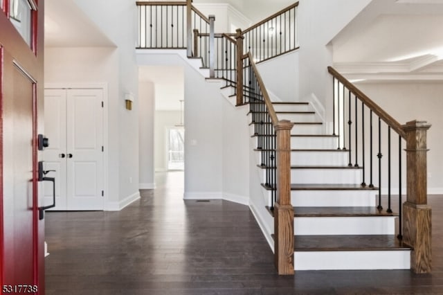 foyer with a towering ceiling and dark hardwood / wood-style floors