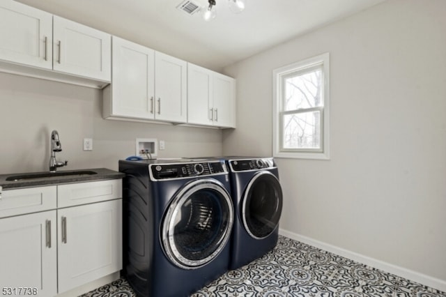 washroom featuring light tile patterned floors, cabinets, sink, and washing machine and clothes dryer