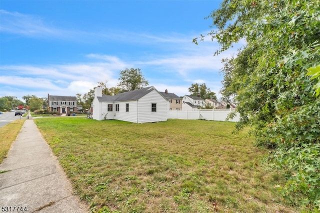 view of side of home with a yard