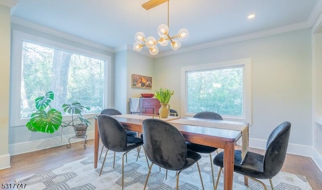 dining room with crown molding, an inviting chandelier, and light hardwood / wood-style floors