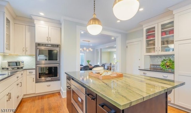 kitchen featuring hanging light fixtures, appliances with stainless steel finishes, and white cabinets