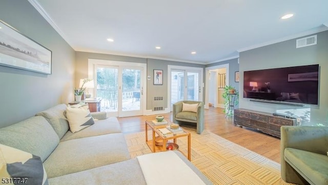 living room with light wood-type flooring and crown molding