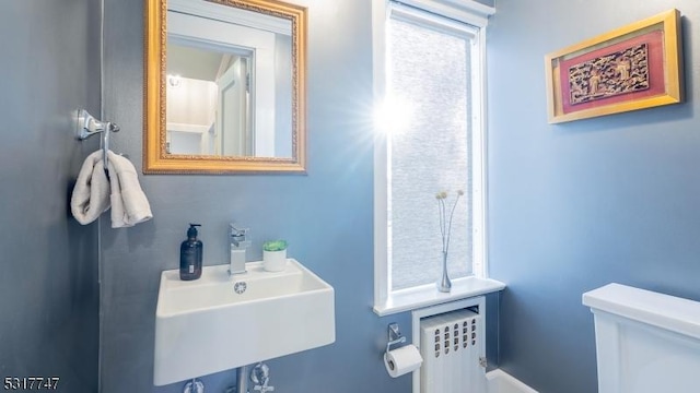 bathroom with sink, toilet, and radiator heating unit