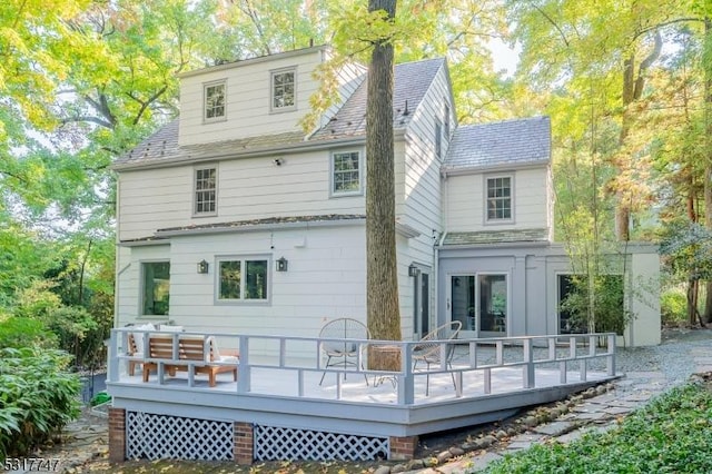 rear view of house featuring a wooden deck