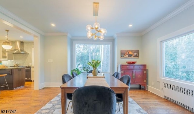 dining space featuring a notable chandelier, light hardwood / wood-style floors, radiator, and ornamental molding