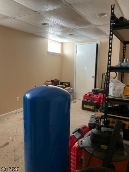 basement featuring carpet and a paneled ceiling