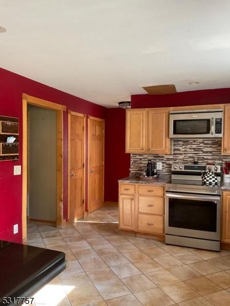 16 Abrams Rd, Holland Twp, NJ 08848 - kitchen with stainless steel appliances, light tile patterned floors, and tasteful backsplash