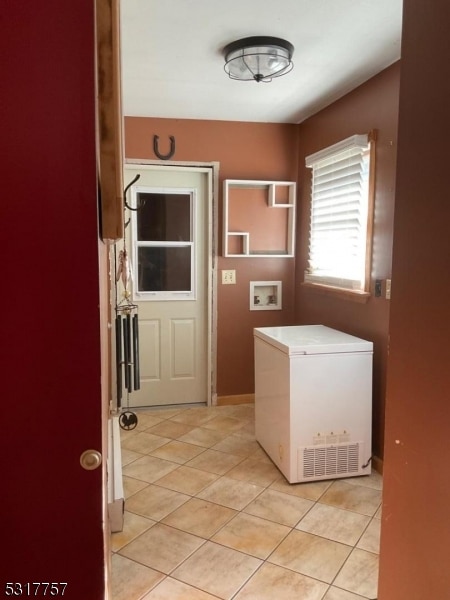 laundry area with washer hookup and light tile patterned floors