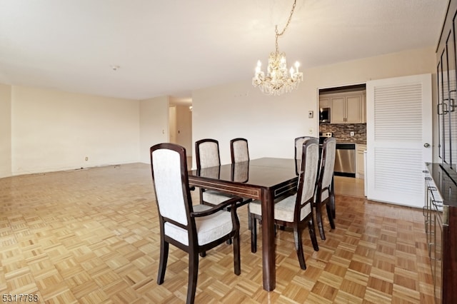 dining room with an inviting chandelier and light parquet floors