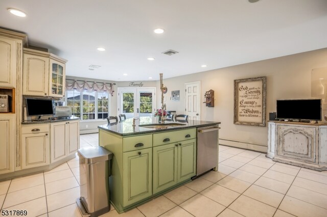 kitchen with green cabinetry, dishwasher, a kitchen island with sink, and light tile patterned flooring