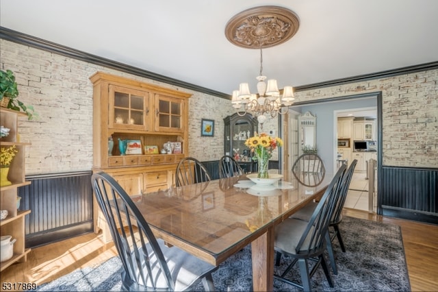 dining area featuring a notable chandelier, hardwood / wood-style floors, and ornamental molding