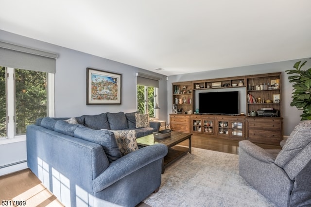 living room with light wood-type flooring and baseboard heating