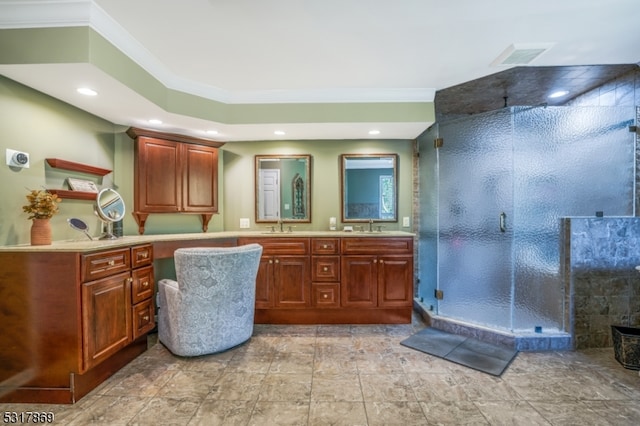 bathroom featuring ornamental molding, vanity, and an enclosed shower