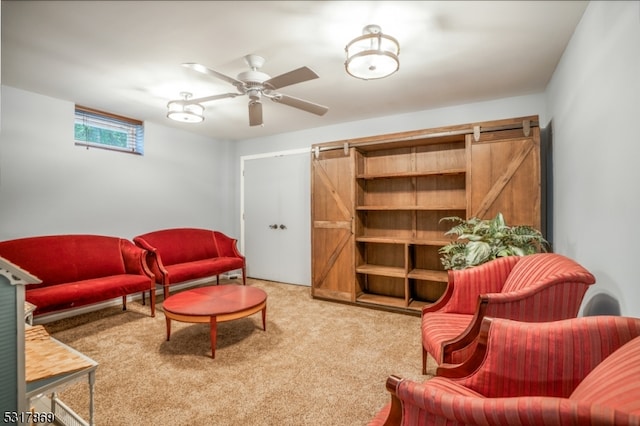 carpeted living room featuring a barn door and ceiling fan