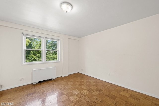 unfurnished room featuring radiator