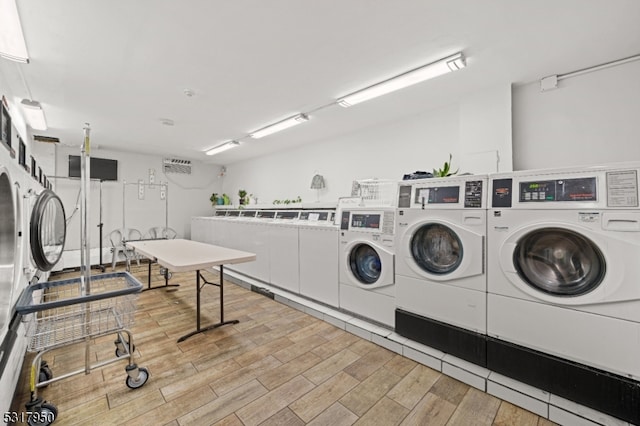 laundry area featuring washer and clothes dryer and light hardwood / wood-style floors