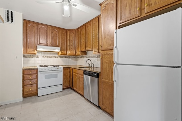 kitchen featuring decorative backsplash, white appliances, sink, and ceiling fan