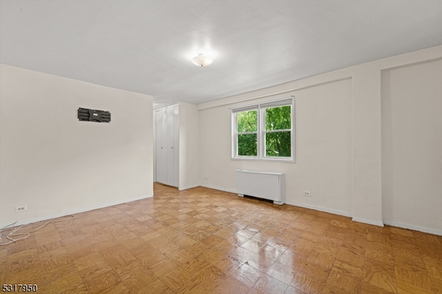 unfurnished room featuring radiator heating unit