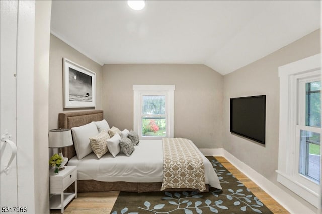 bedroom featuring lofted ceiling and hardwood / wood-style floors