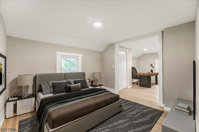 bedroom with lofted ceiling and hardwood / wood-style floors