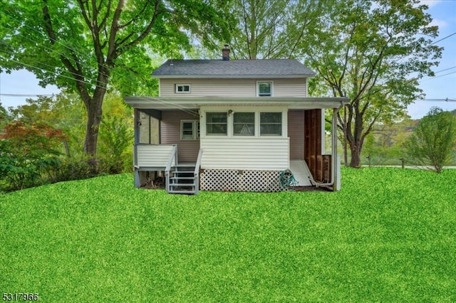 rear view of property featuring a lawn