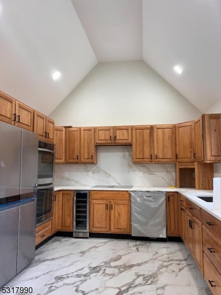 kitchen with high vaulted ceiling, stainless steel appliances, beverage cooler, and backsplash