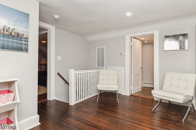 living area with dark hardwood / wood-style floors and baseboard heating