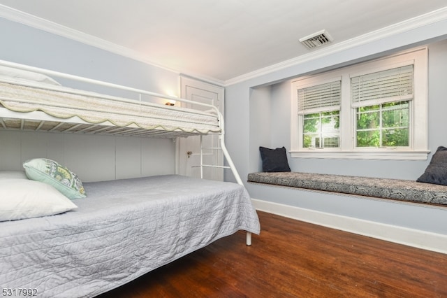 bedroom featuring crown molding and dark hardwood / wood-style floors