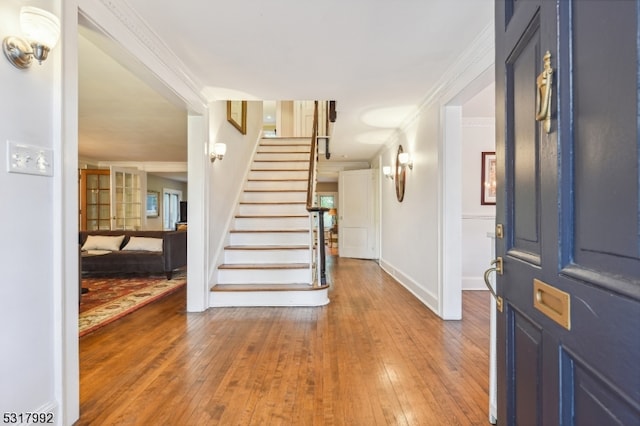 entryway with hardwood / wood-style flooring and ornamental molding