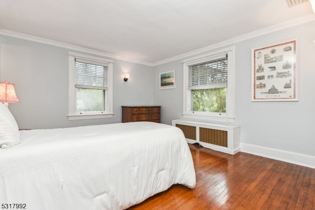 bedroom featuring hardwood / wood-style flooring, ornamental molding, and radiator heating unit